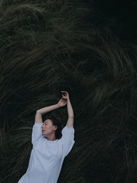 a woman laying in a field of grass