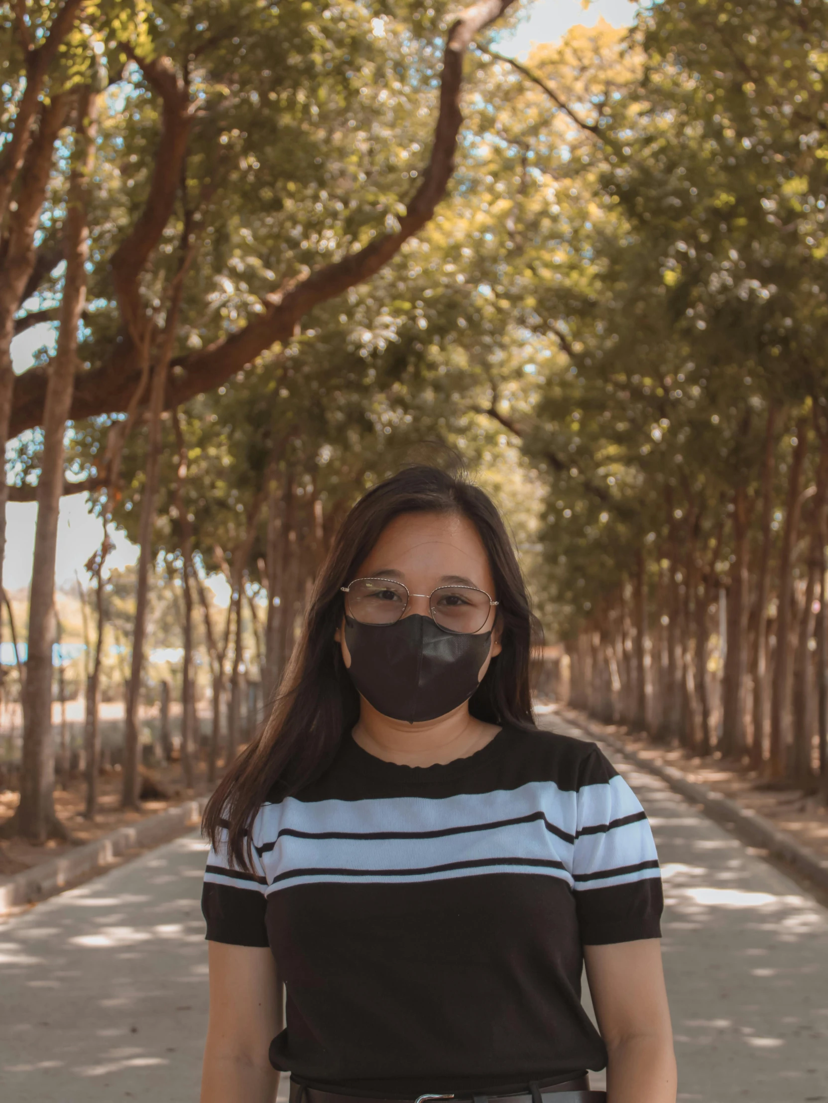 a woman in a striped shirt and black mask