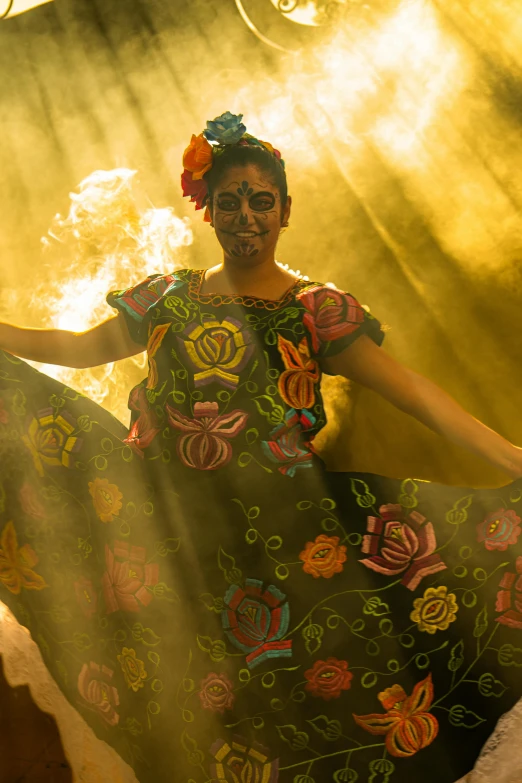 woman in ornate dress on stage with yellow and orange background