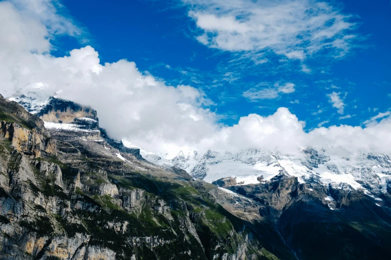 mountains and clouds with a train in the foreground