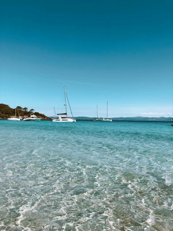 boats are floating on the ocean in a calm cove