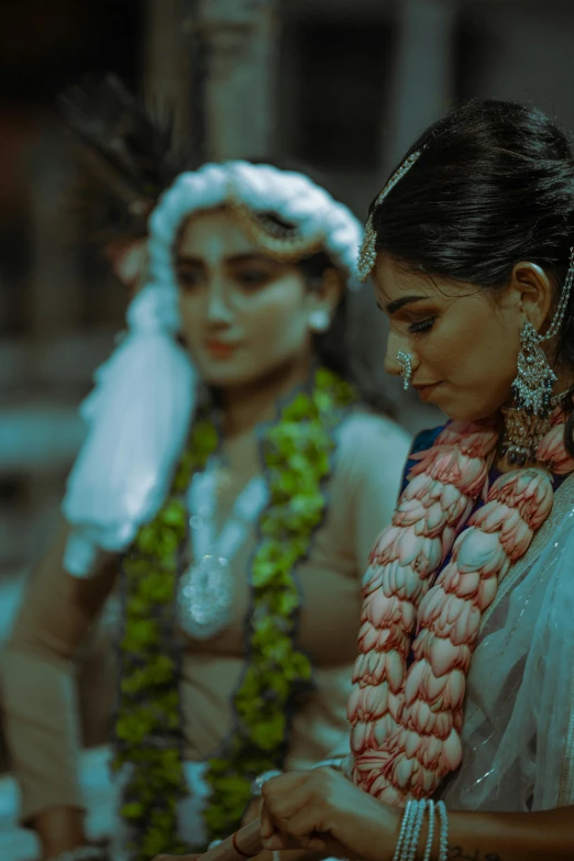 two young women wearing costume and jewelry, both standing