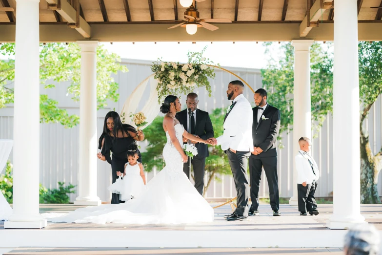 a bride and groom are under a gazebo