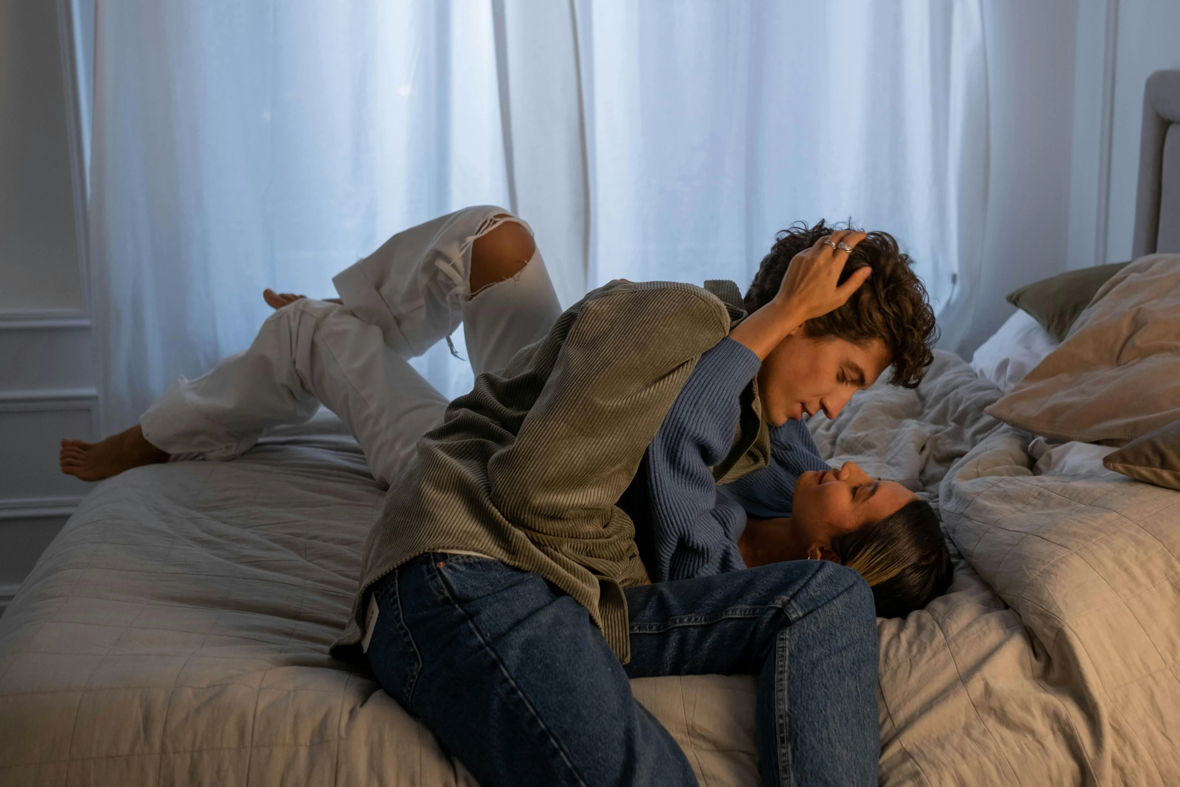 two people laying on top of the bed