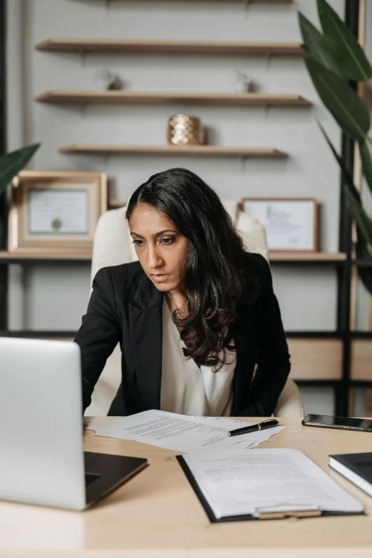 a woman in business attire writing in an open book