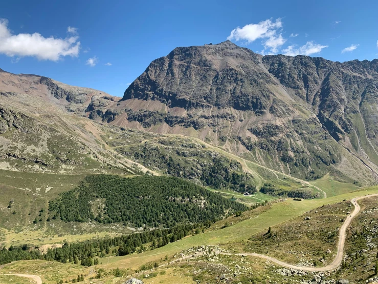 a beautiful mountain scene with a road winding between the mountains