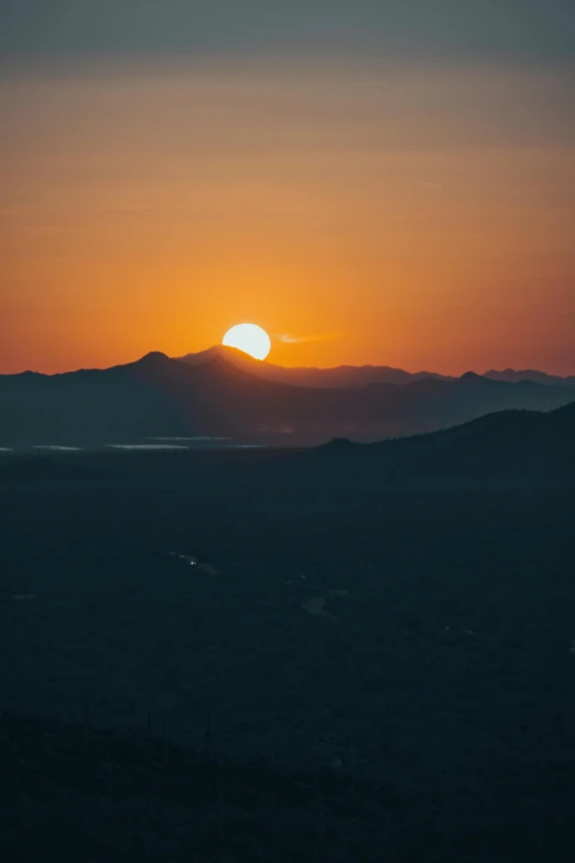 the sun is setting in the mountains with a black background