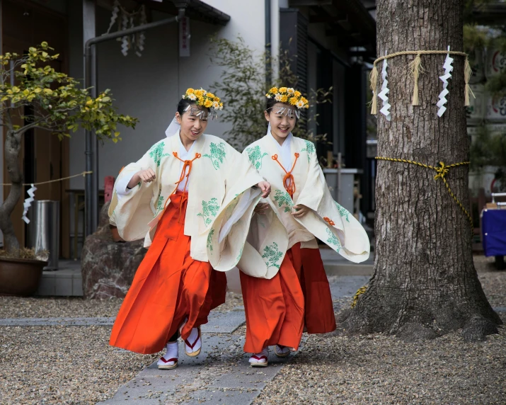 two asian woman are walking along a path