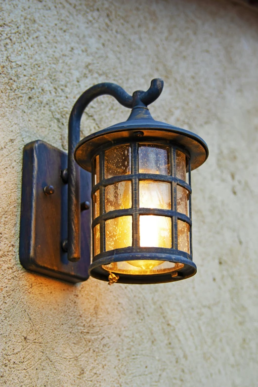 an old fashioned light hanging on the side of a building