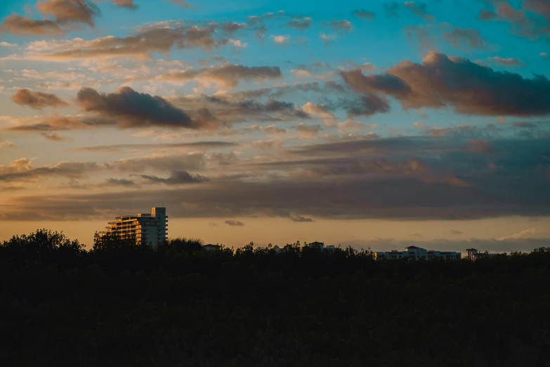 the tower of a building stands behind the sky