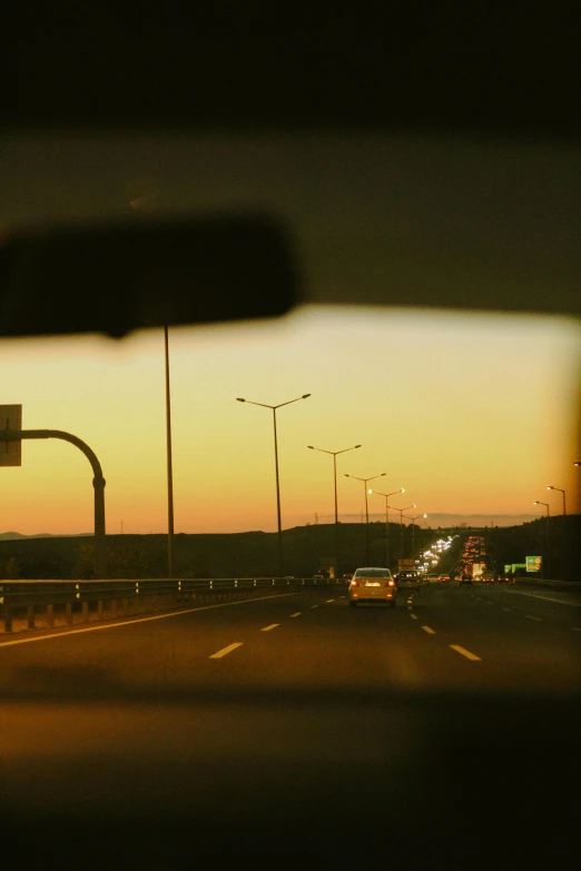 a car at a traffic light is seen at dusk