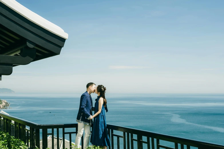 a beautiful couple on top of a hill near the water