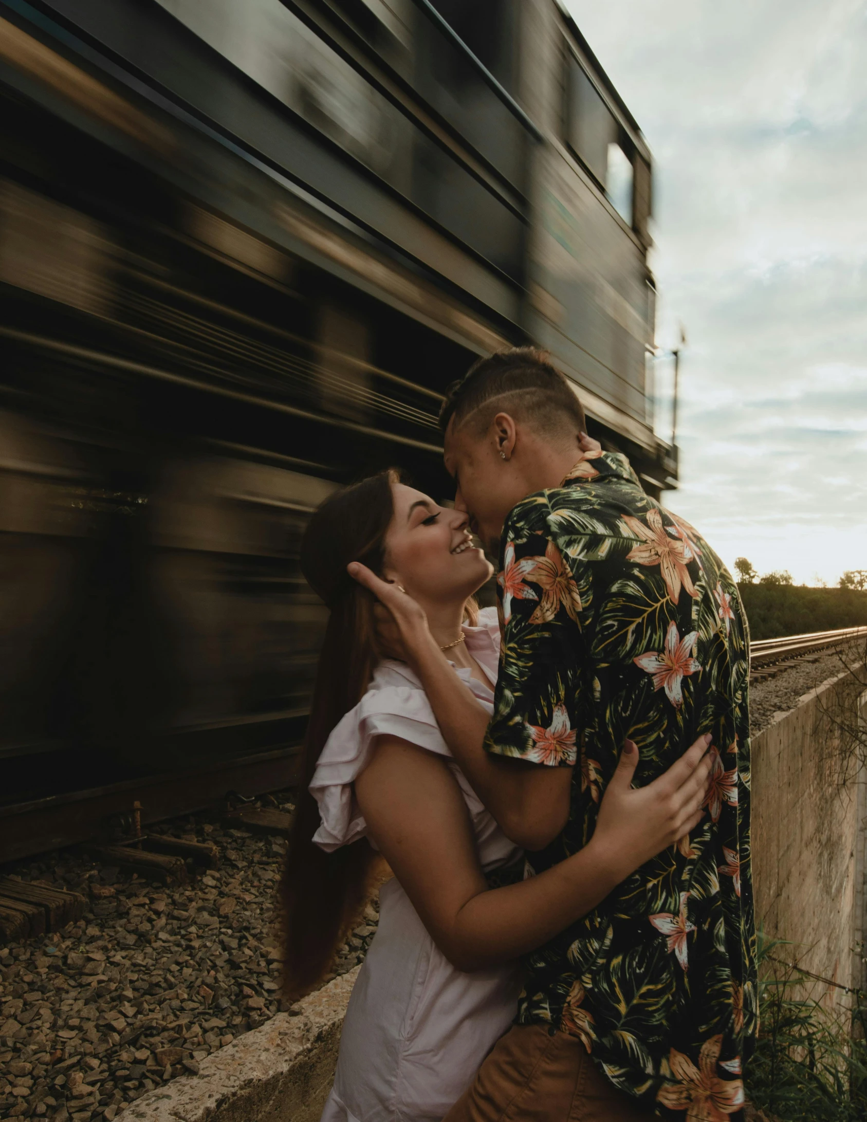 a man and woman emcing beside a train