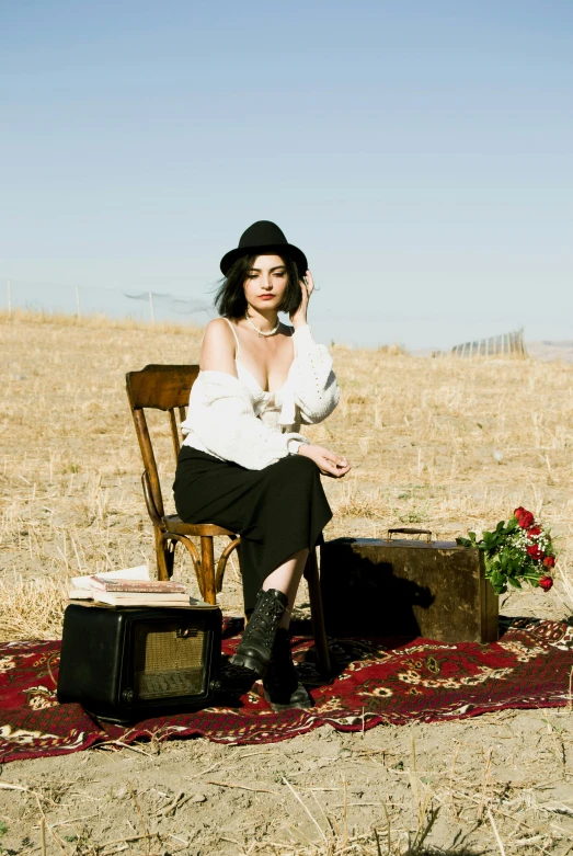 a women sitting in a chair in an empty field
