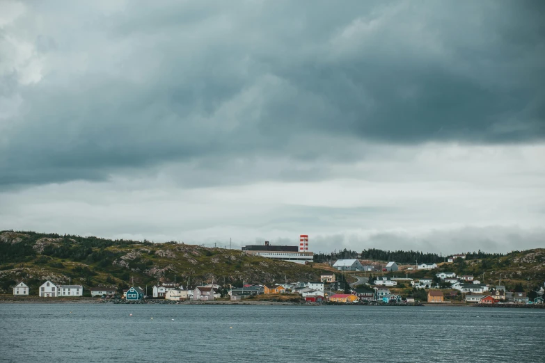 a city next to a body of water with a cloudy sky