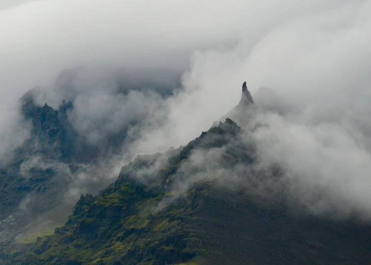 a mountain top that is covered in fog