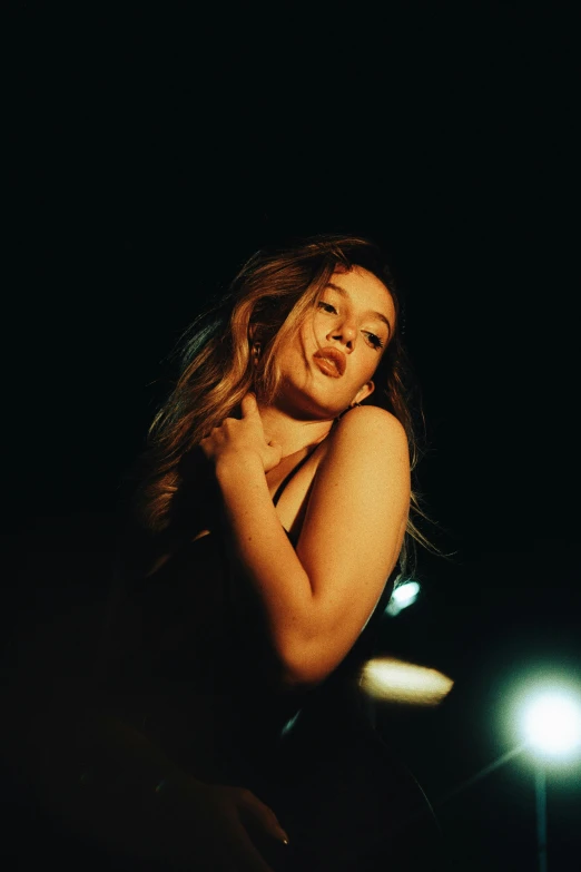 the woman is posing for the camera under a street light