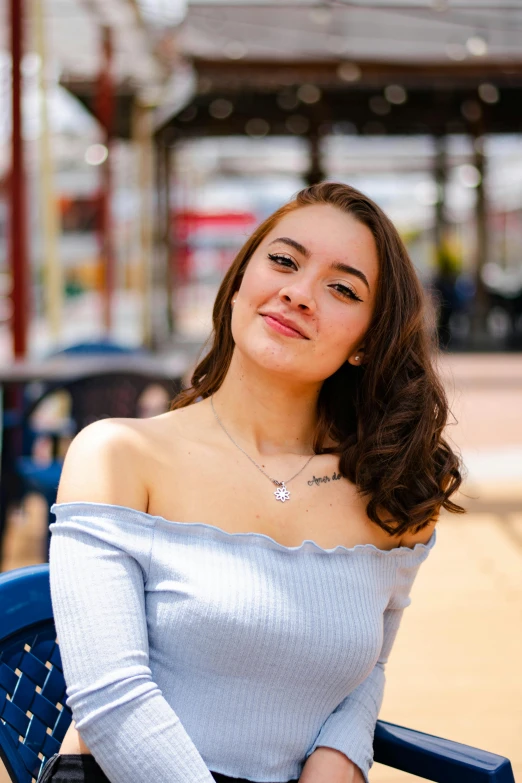 a pretty woman sitting on a chair smiling