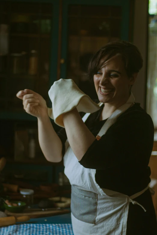 a woman holding up a piece of fabric