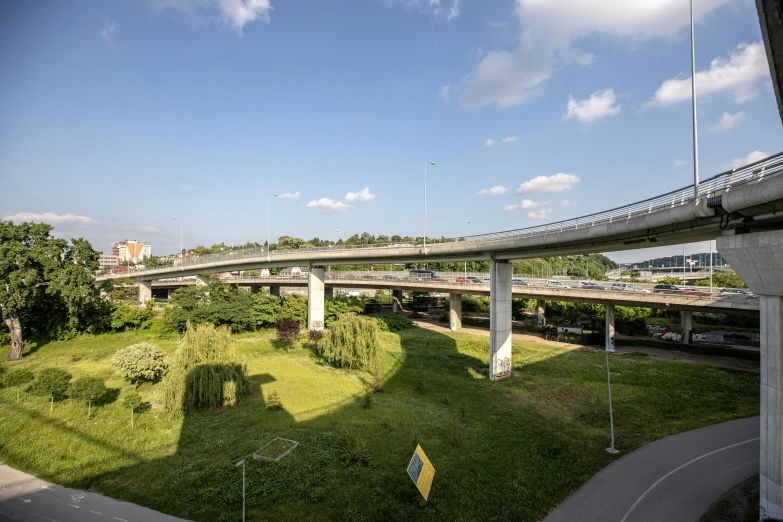 view looking down on a freeway above a lush green park