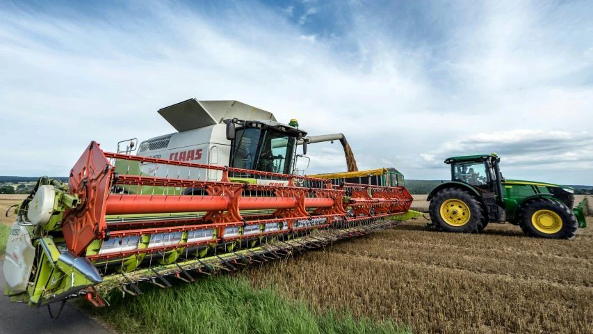 a green tractor and some kind of red bale