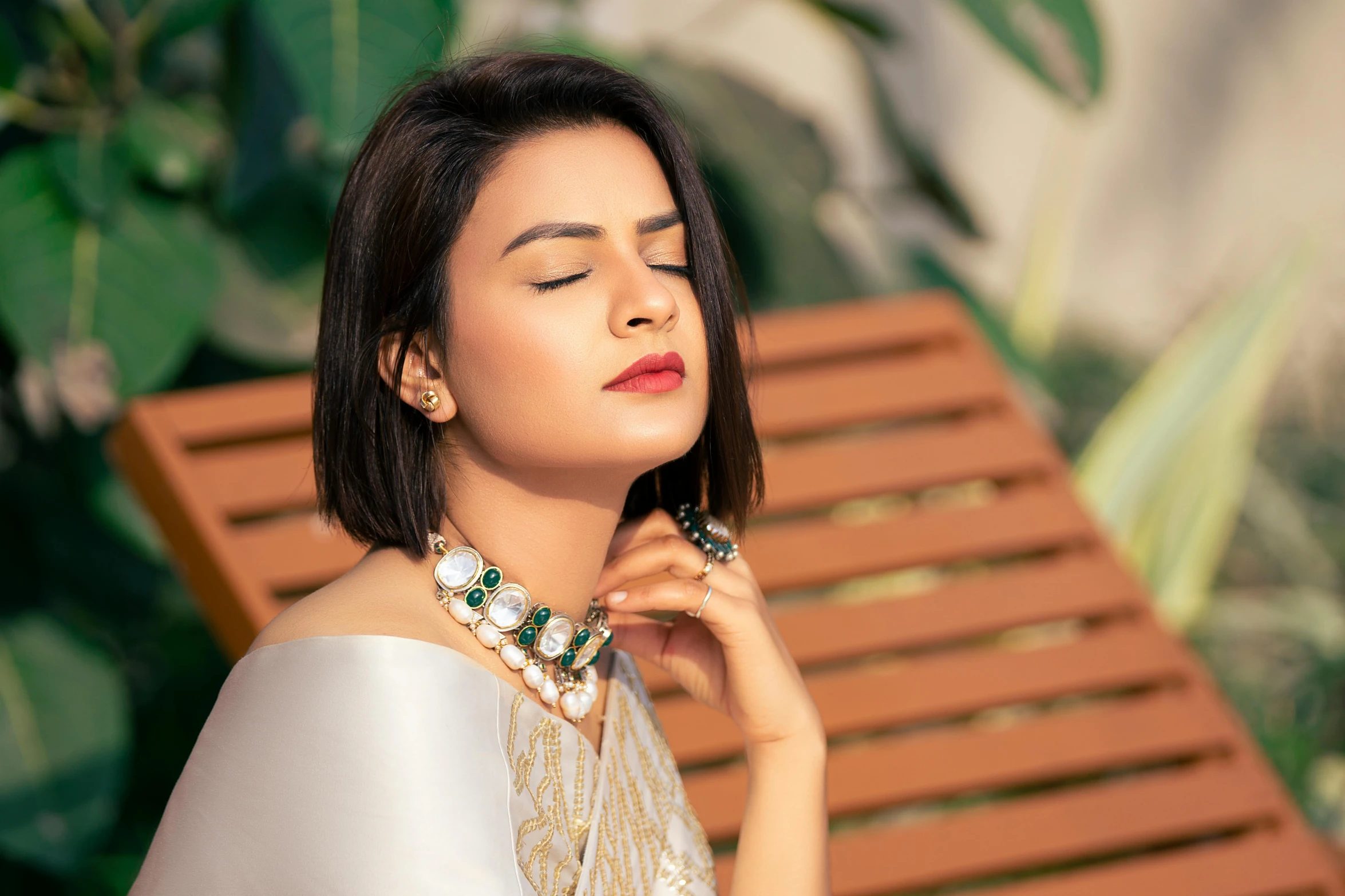 a woman sitting on a wooden bench with her eyes closed