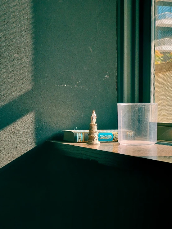 a small statue sitting on top of a shelf next to a window