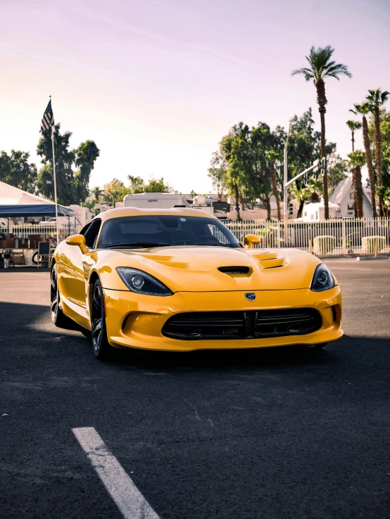 a yellow sports car sits parked in a parking lot