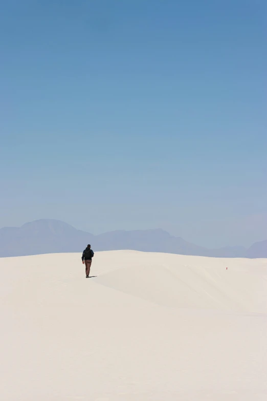 person walking in the middle of a large, flat expanse