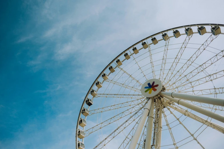 a white ferris wheel is shown against the blue sky