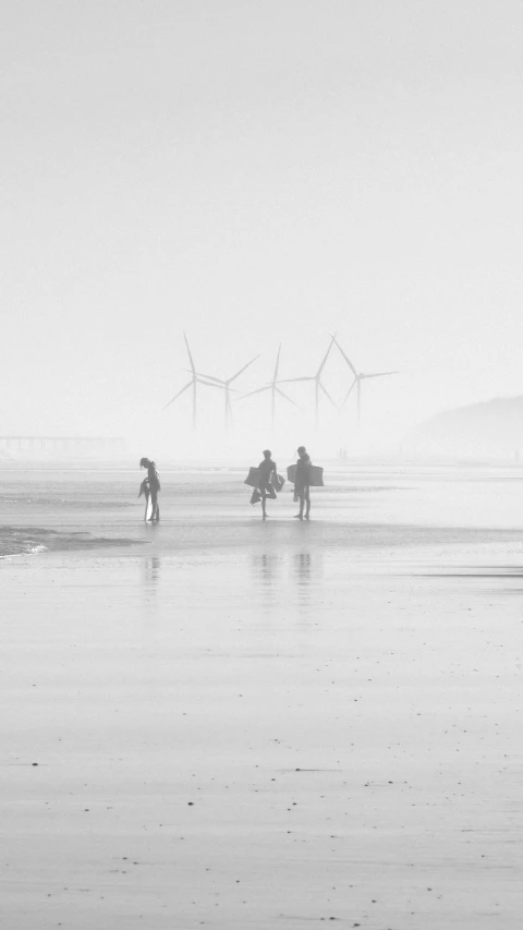 a group of people on a wet beach carrying umbrellas