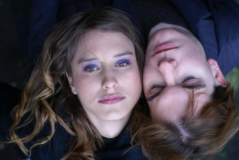 a beautiful young woman laying next to a man