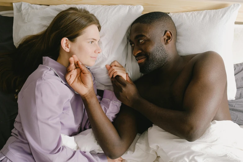 a man and woman are laying in bed together