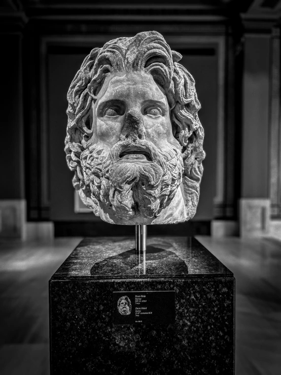 a bust of a man sitting on top of a marble block