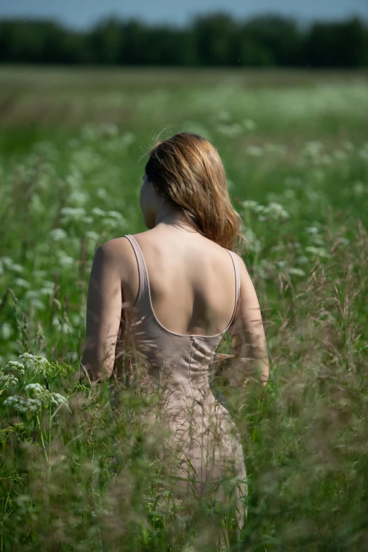 a woman in the middle of a field of tall grass