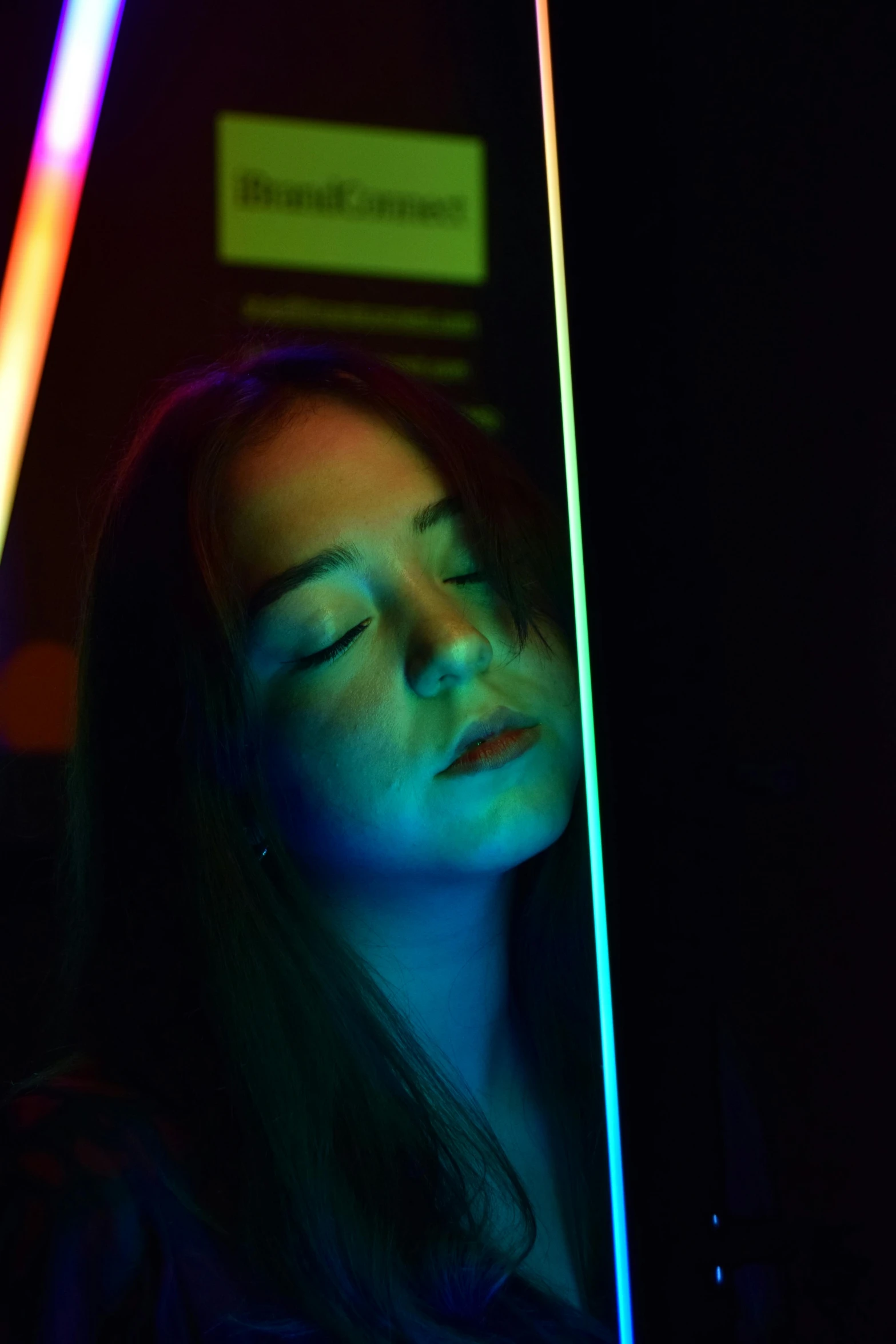 a woman's face is seen through the neon colored poles