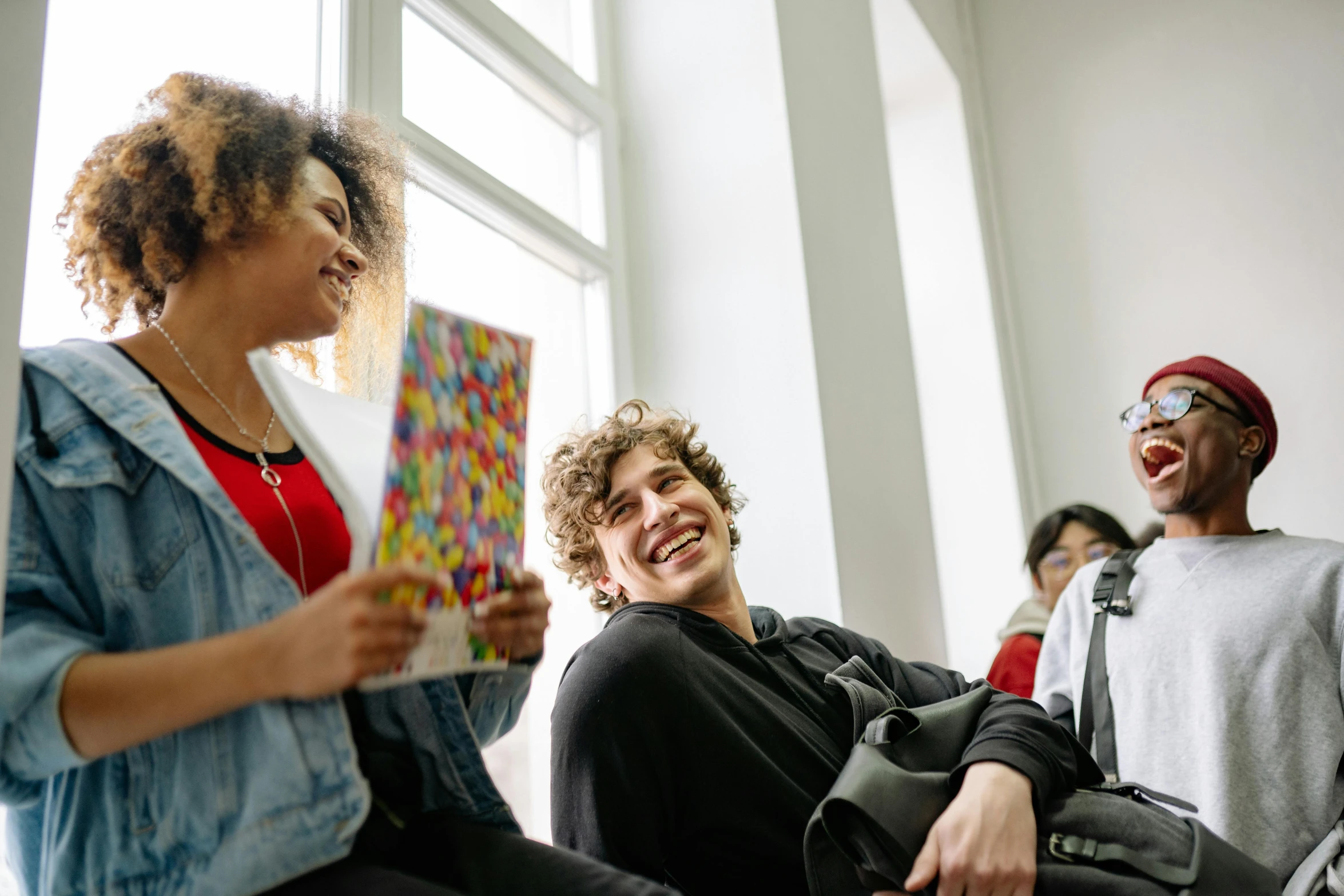 two young people sitting down holding some kind of art piece