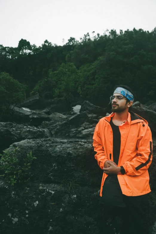 a man is posing on a hill near trees