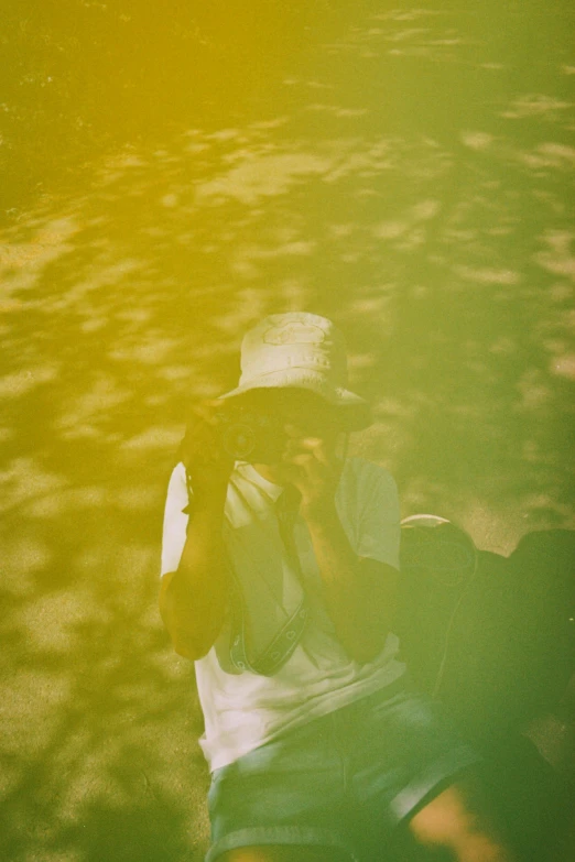 a man with a hat on sitting in a field