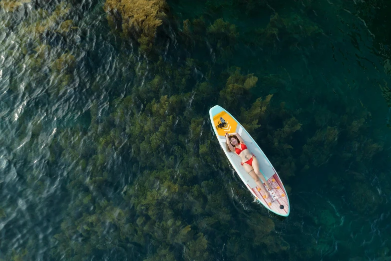 an aerial view of a person riding in a canoe on water