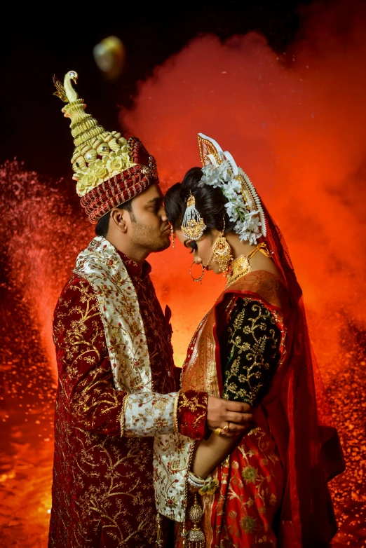 a man and woman in traditional indian garb holding each other