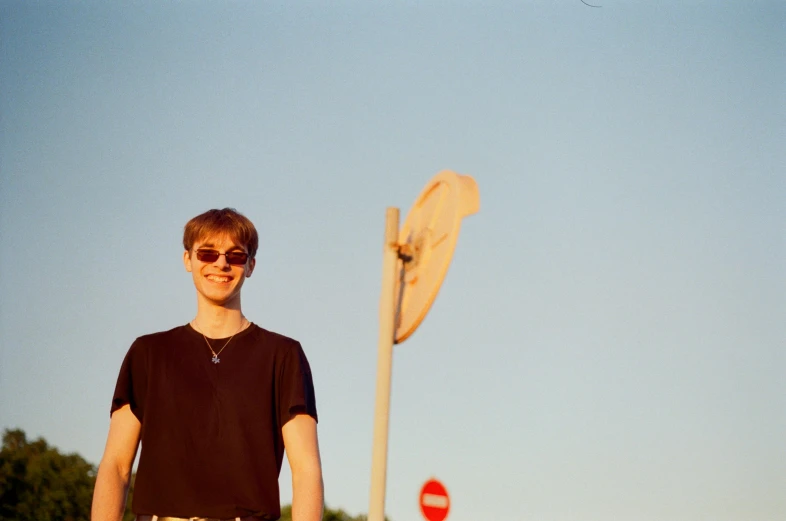 a man standing next to a pole with an umbrella in the background