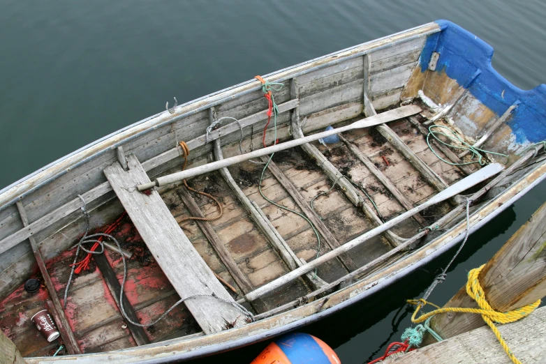 the small fishing boat is tied to the pier