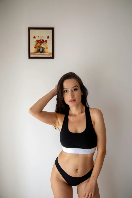 a woman wearing a black bikini top and matching panties poses in her underwear