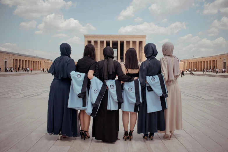a group of women are standing together at a monument