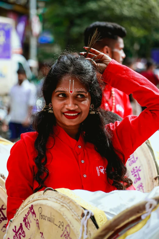 a woman is posing while holding onto some drums