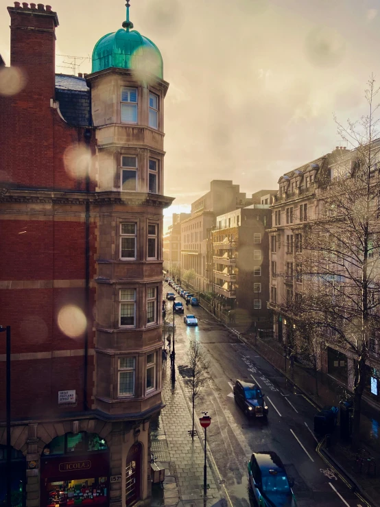 cars are parked on the street as the sun sets