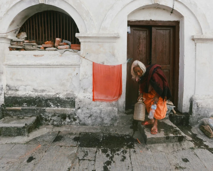 a man with a bucket kneeling next to a door