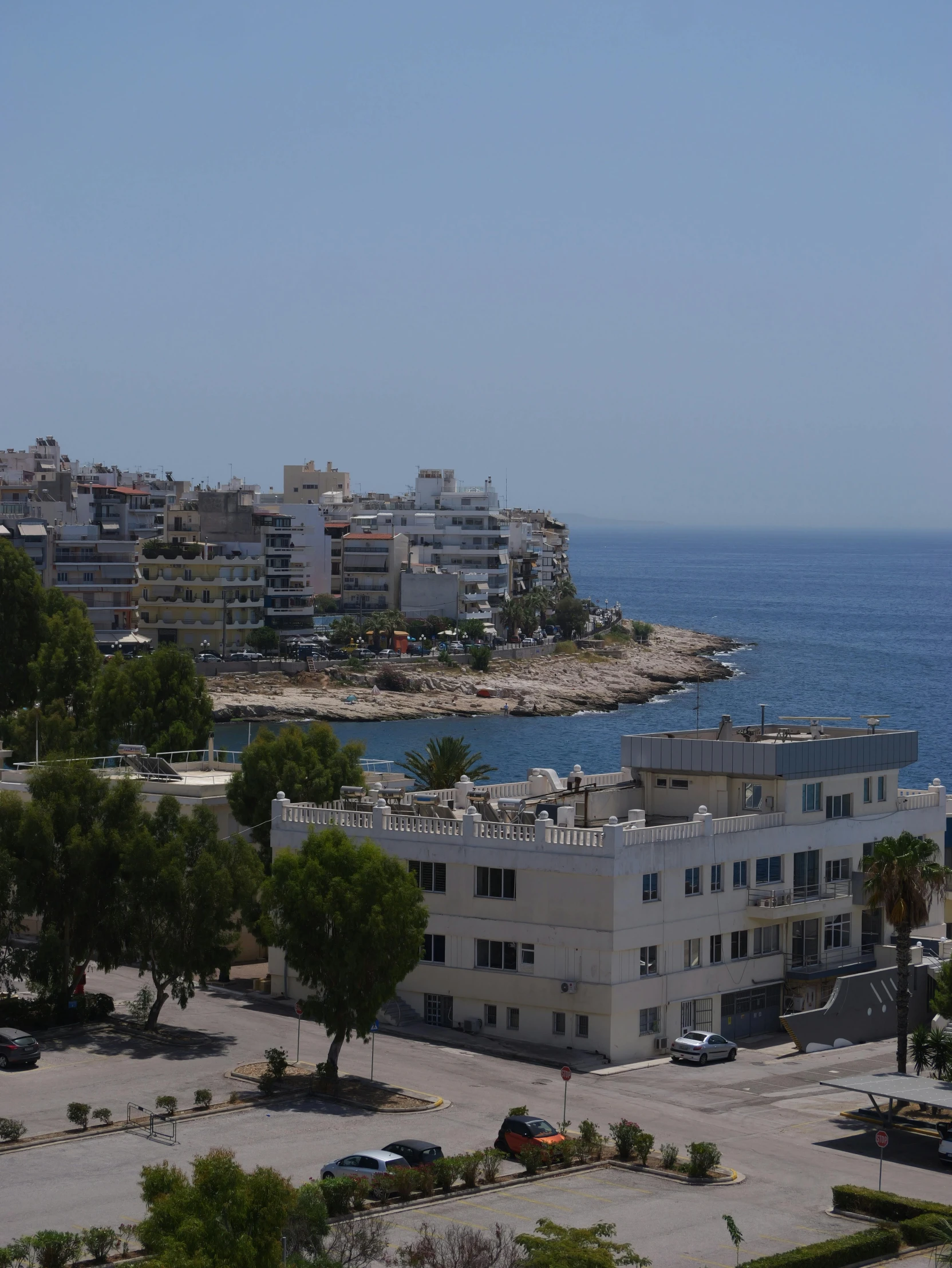 an apartment complex is in the foreground of an ocean view