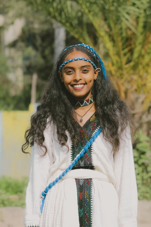 a girl with a colorful head band in a white dress